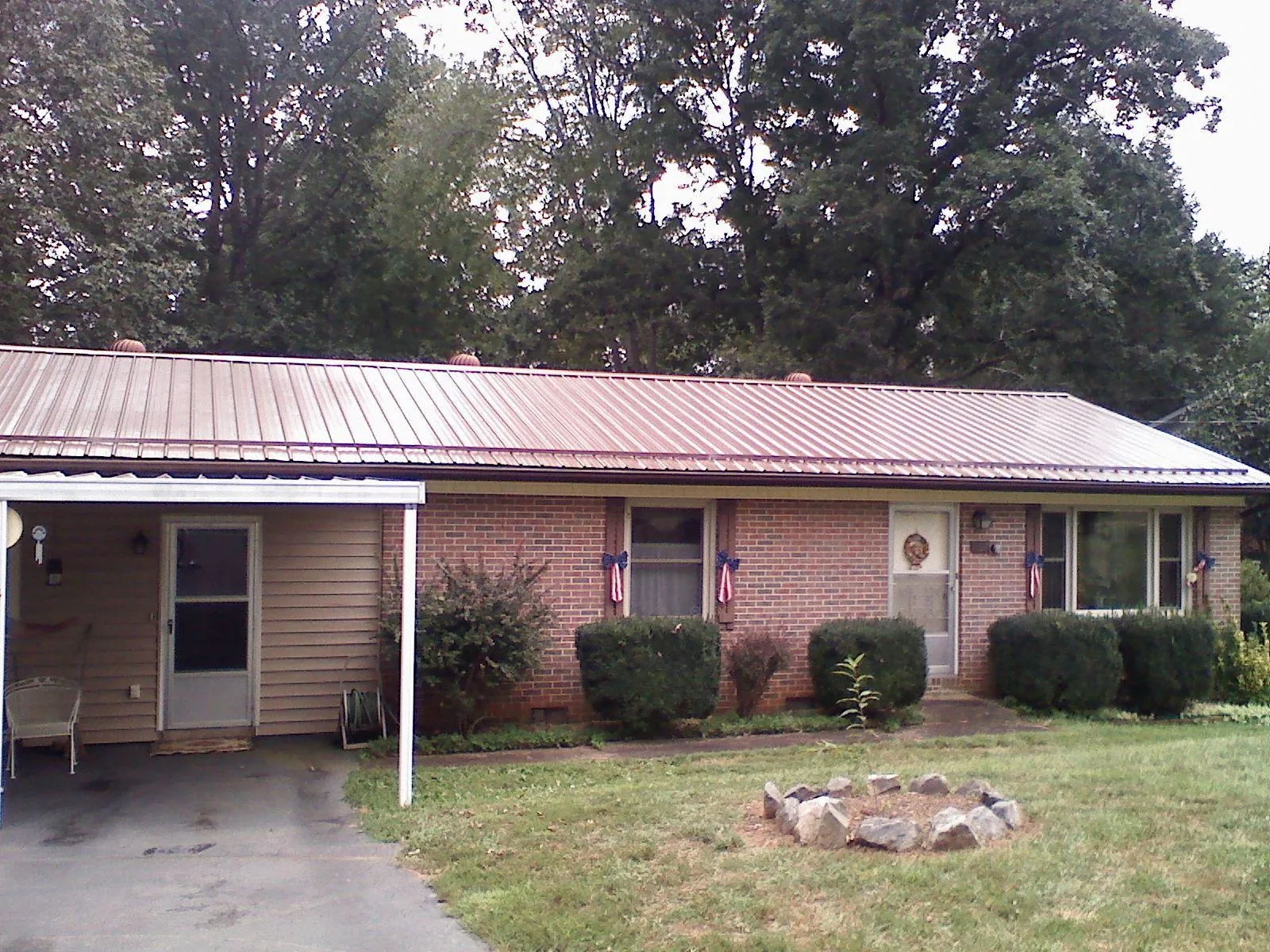 Bronze metal roof and carport on a brick ranch home — Roof Repair work by our crew in Rocky